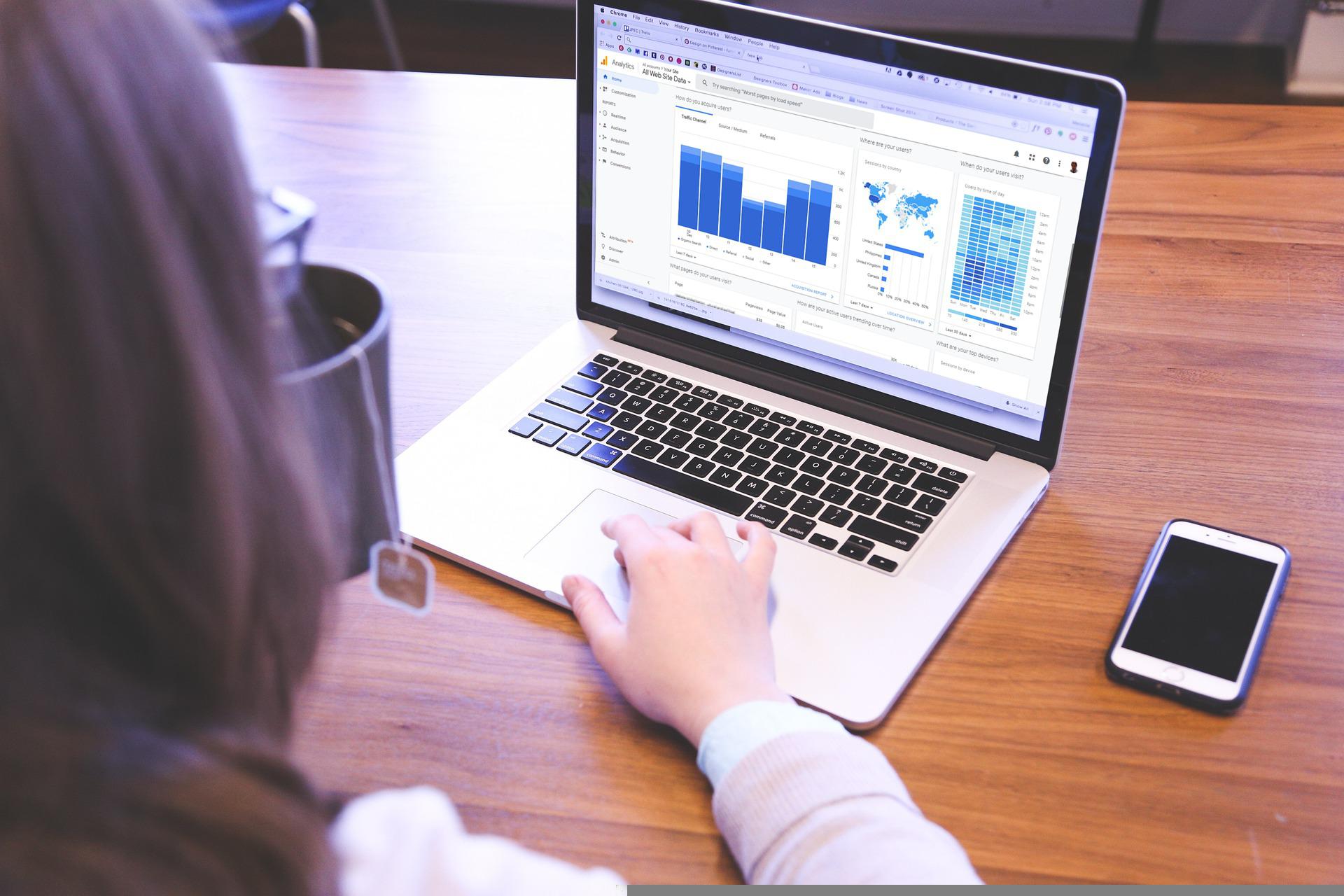 A woman viewing website analytics data on a laptop.